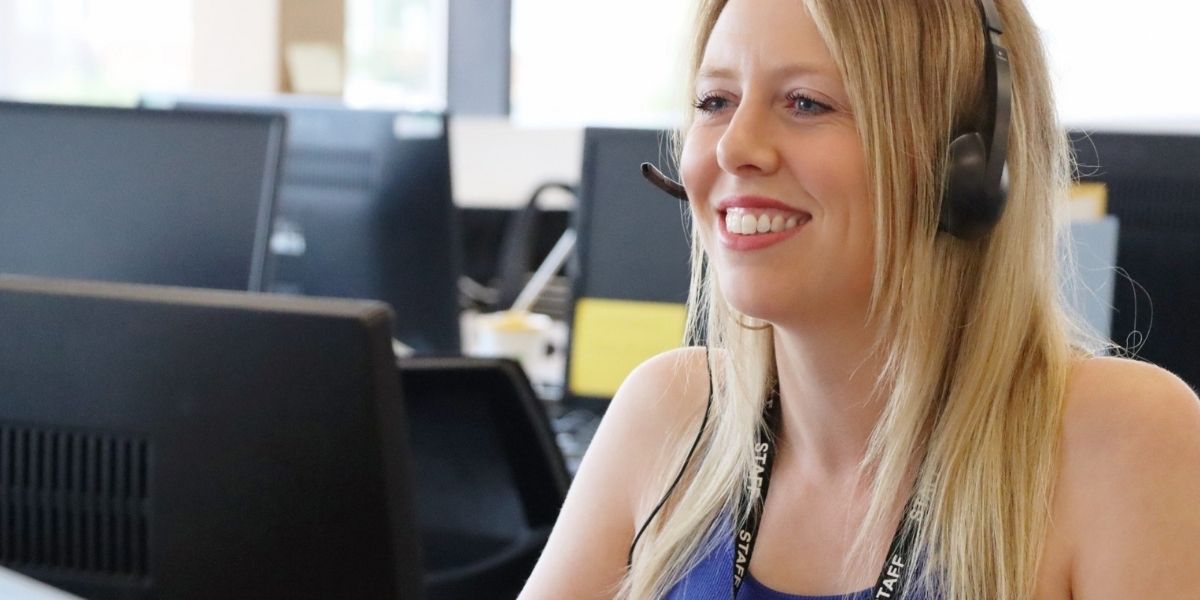a female member of the admissions team offers guidance on the phone at Wrexham University during the Clearing period.