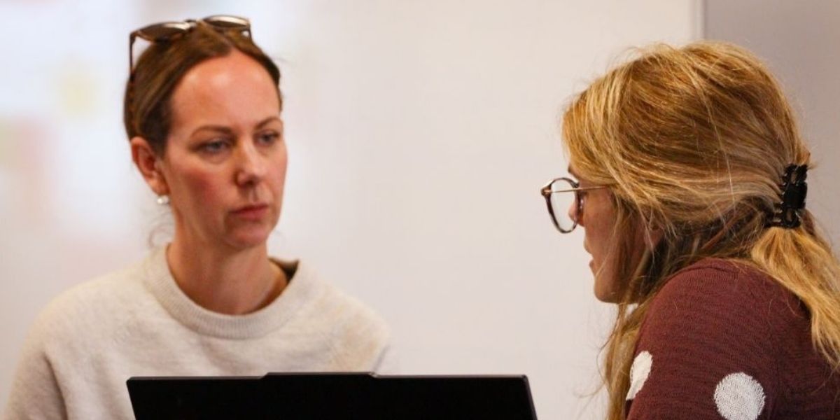 A female parent or supporter sits with a Wrexham University lecturer taking advice during the Clearing period.