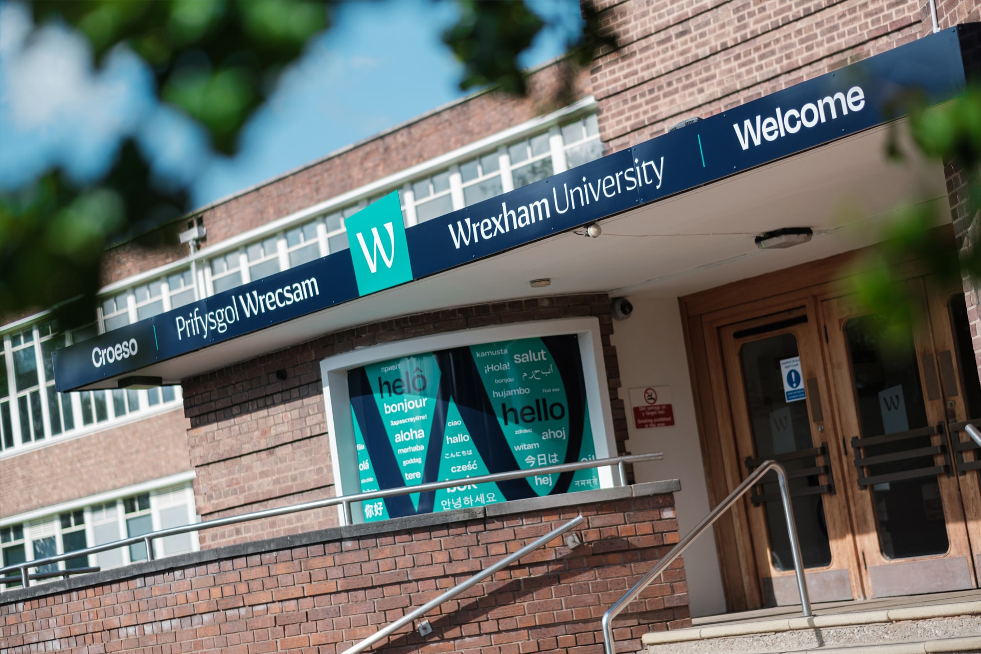 The image shows the front entrance of Wrexham University into the foyer on a sunny day.