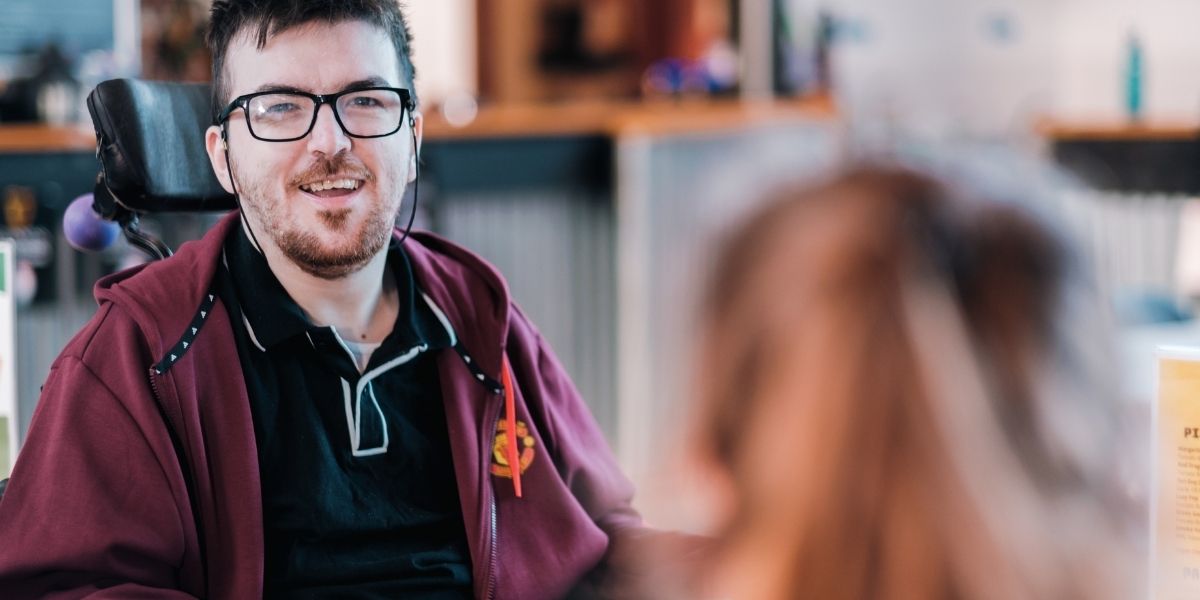 A student with a disability receives advice from a member of staff at Wrexham University