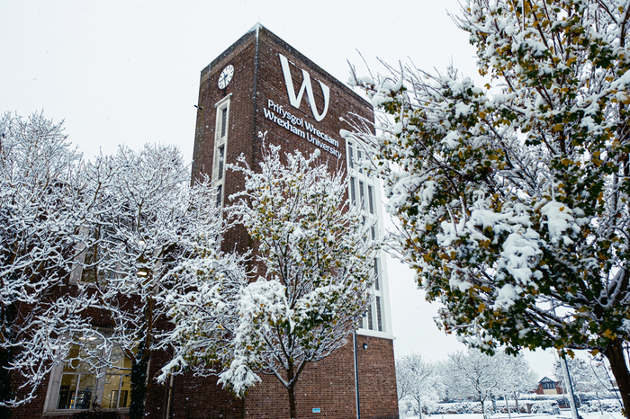 Snow on university building and surrounding trees