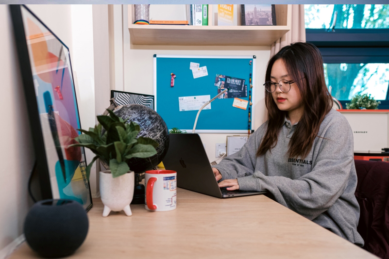 Student on laptop in campus accommodation