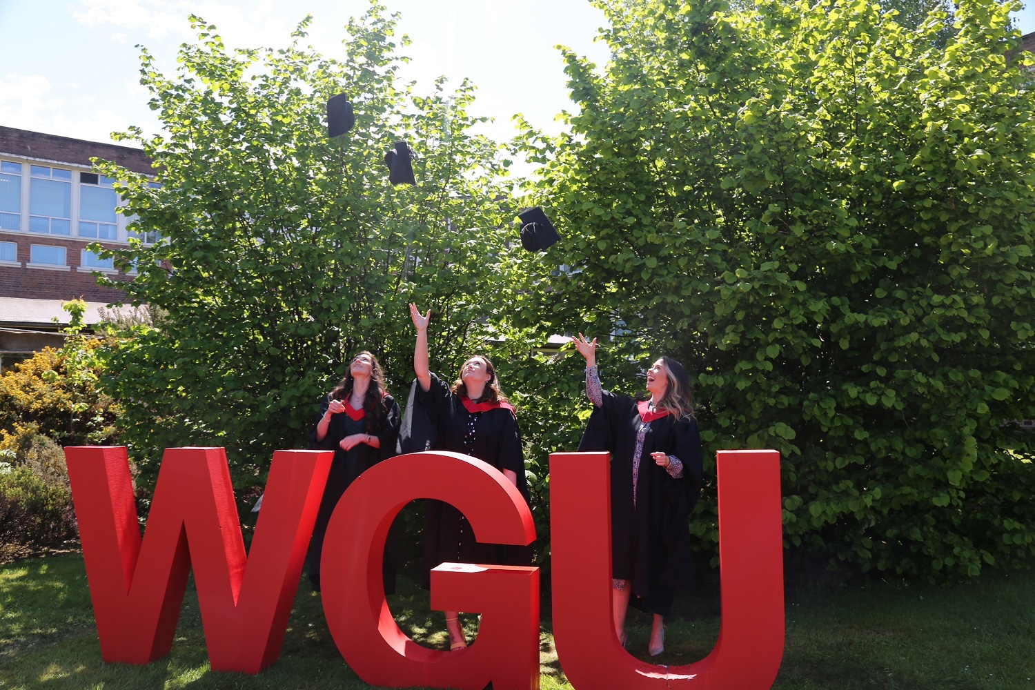 graduates throwing hat in air