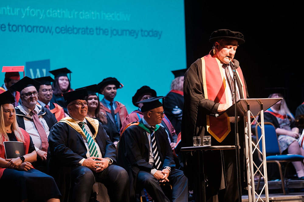 Speaker on stage with people in the background