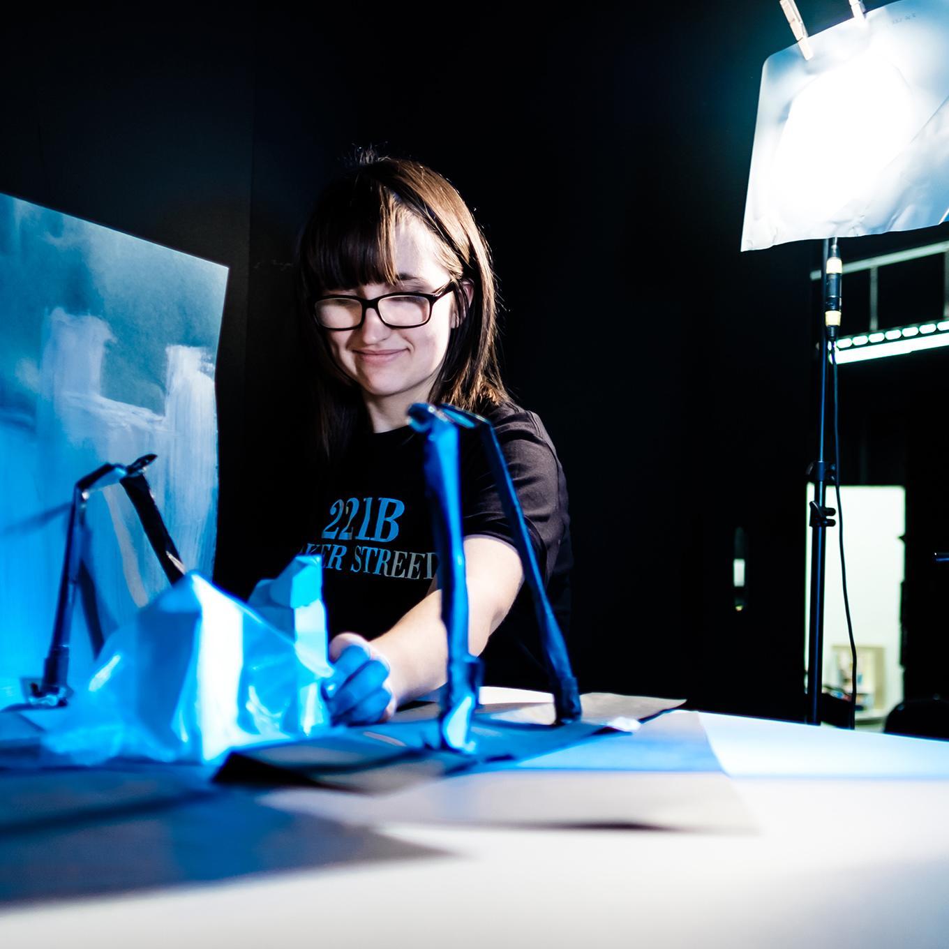 A student arranges props and models for a stop-motion animation shoot