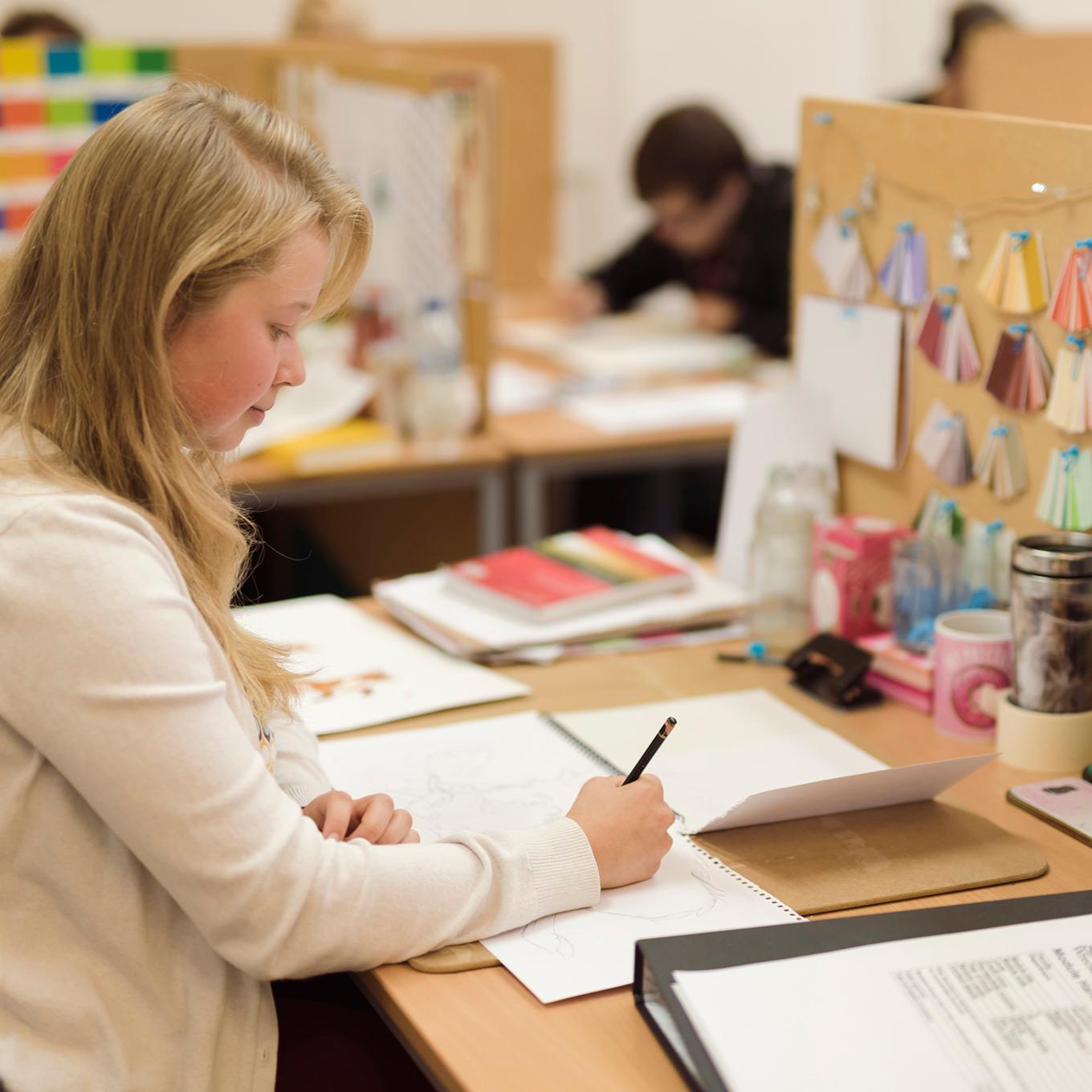 An illustration student works on a project at her workspace