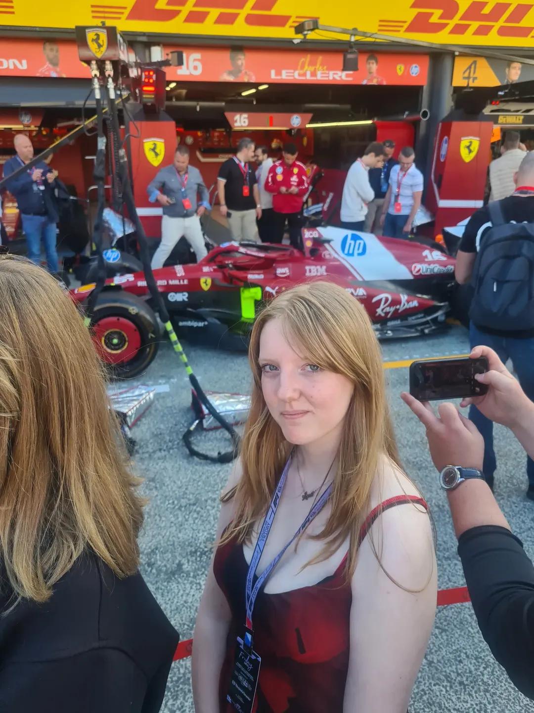 A student standing beside a car at the Grand Prix