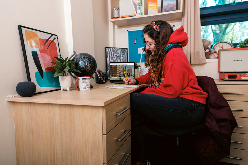 student writing at a desk