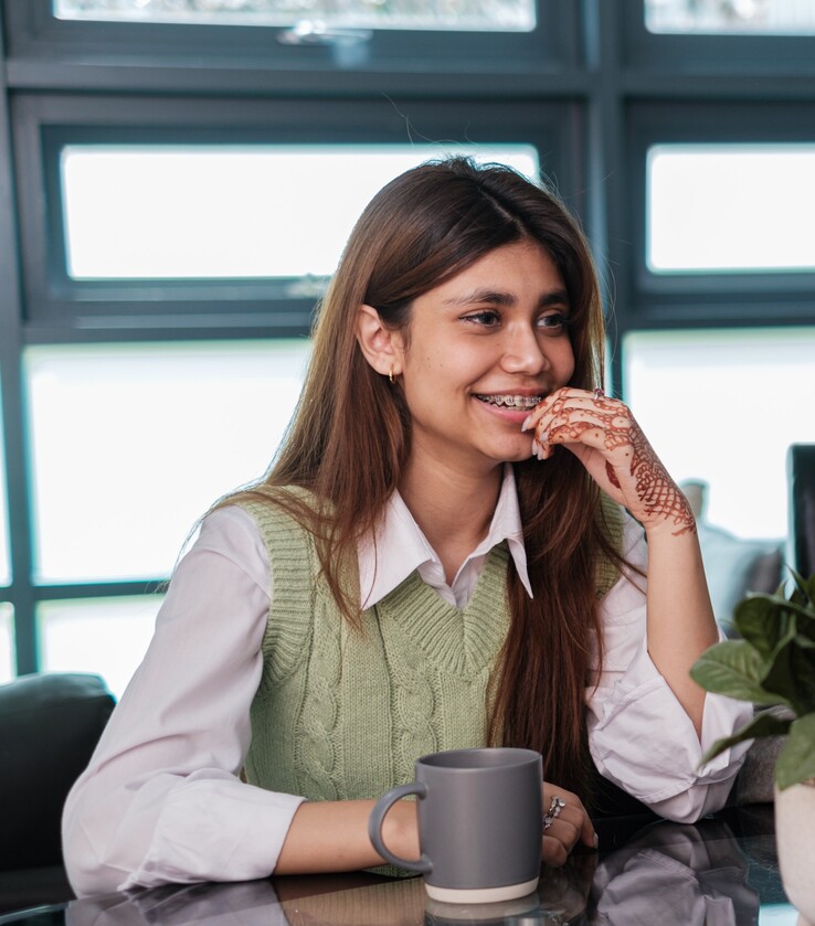 Student smiling in front of table