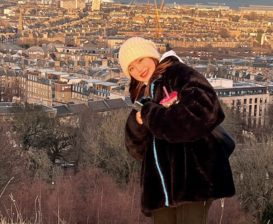 student smiling in front of city