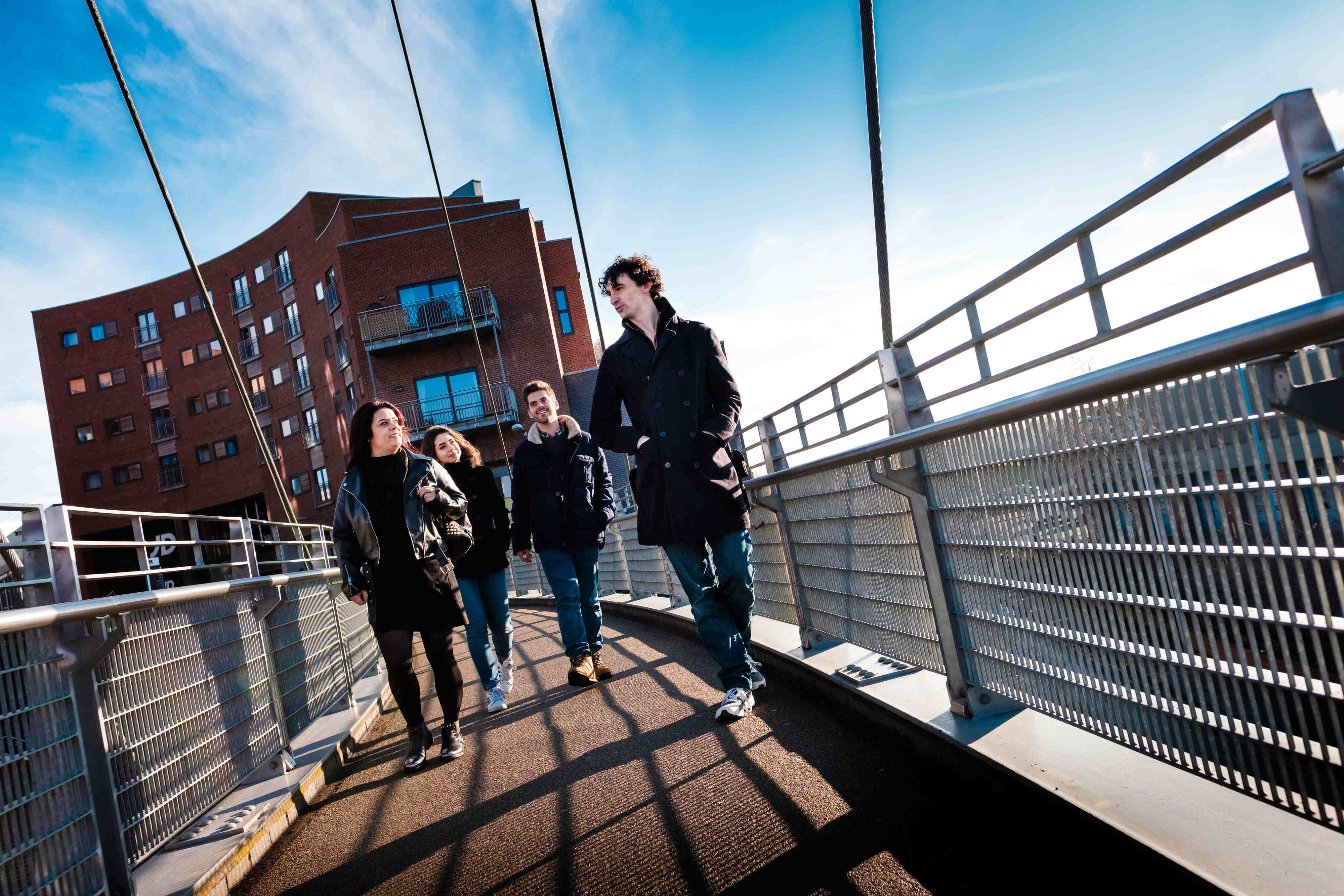 Students walking across bridge chatting