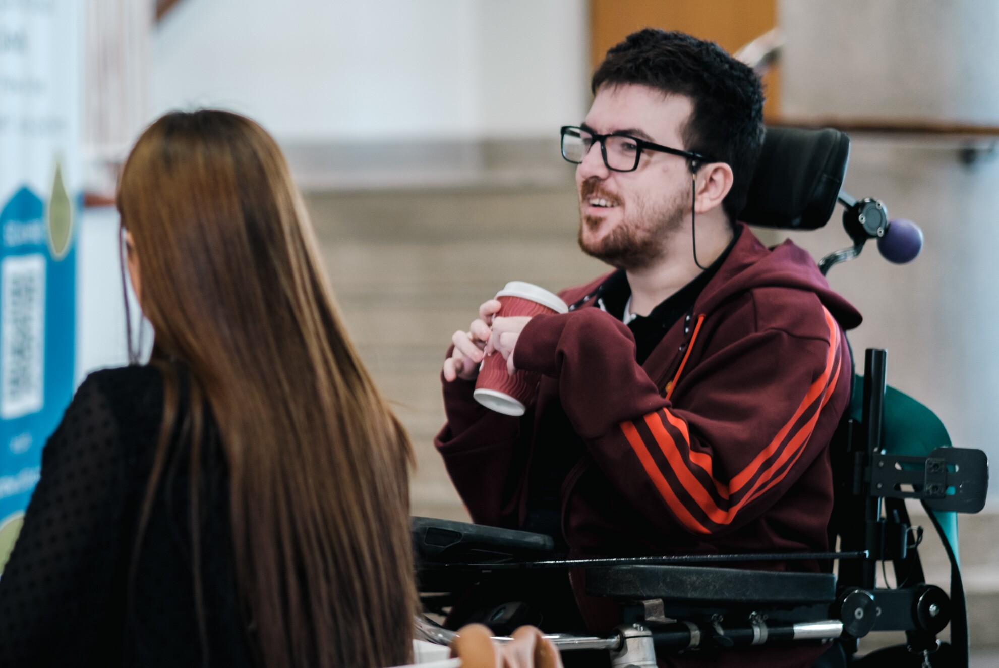 student in wheelchair with coffee cup