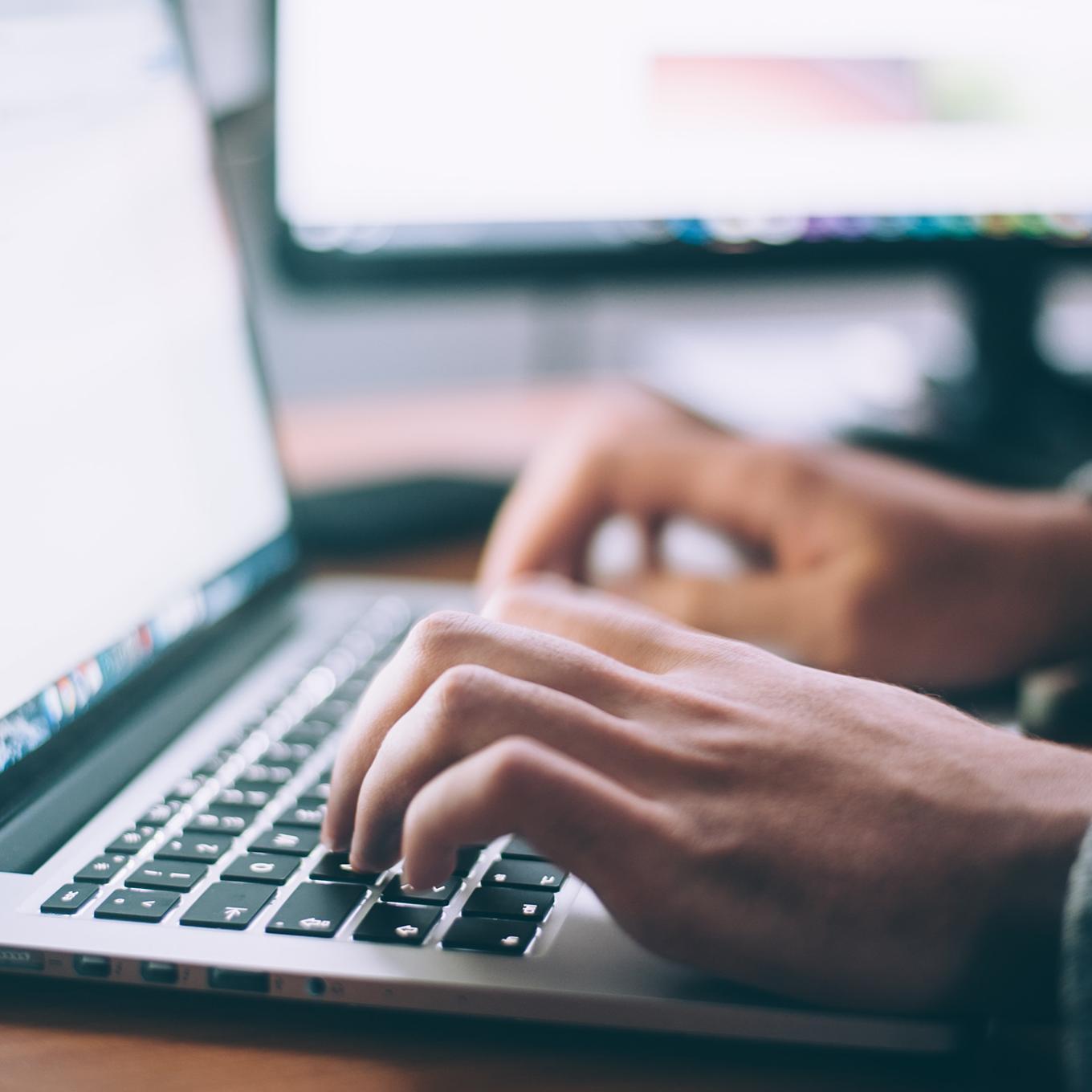 Close up of hands on a laptop keyboard