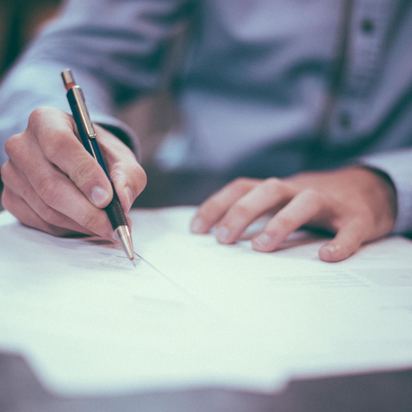 Smartly dressed person making notes on a document