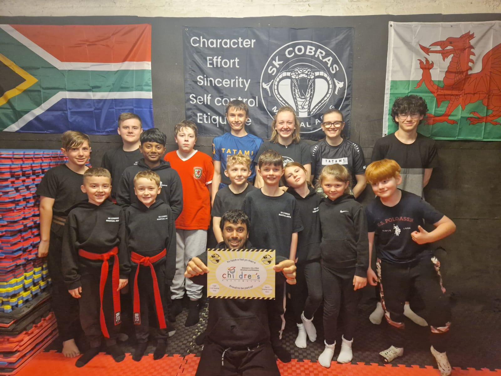 Group of kids and instructor holding learning destination poster