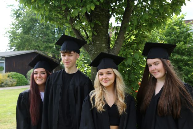 Teenages graduating in caps and gowns