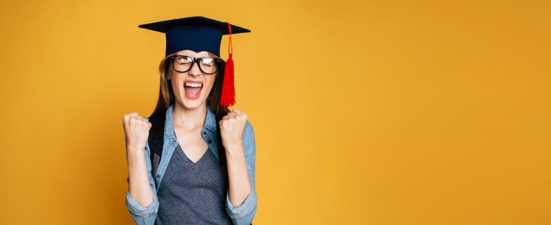 Teenage girl wearing a mortarboard who is celebrating.