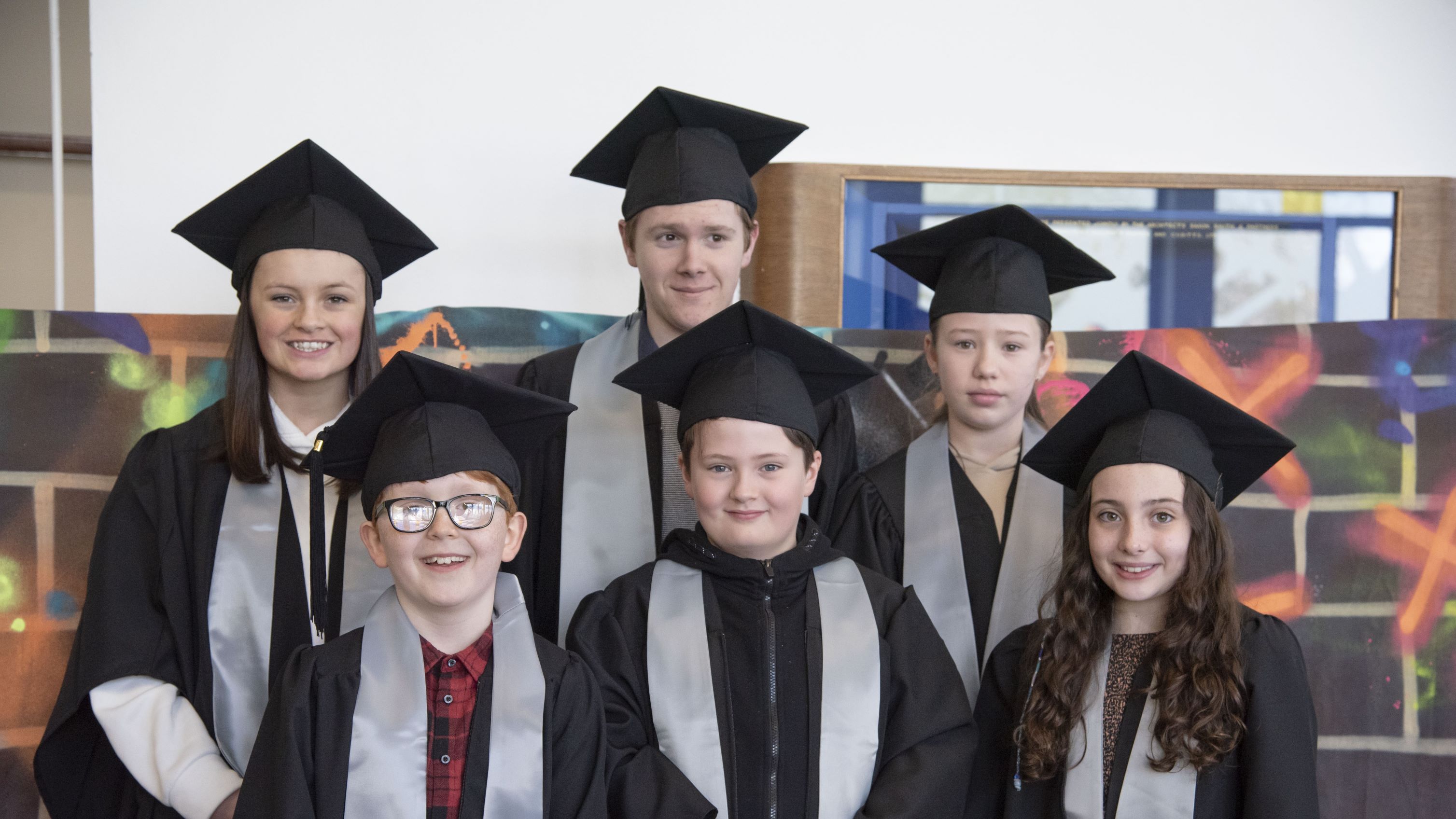 A grup of young people stood together to take a picture in their Children's University cap and gowns.