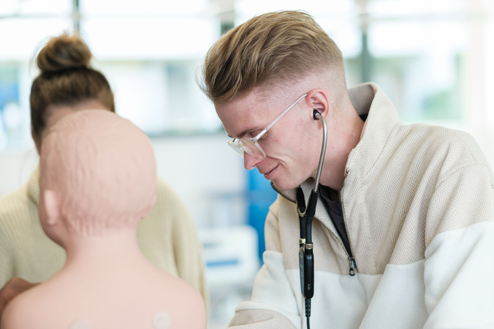A student inspecting a medical dummy