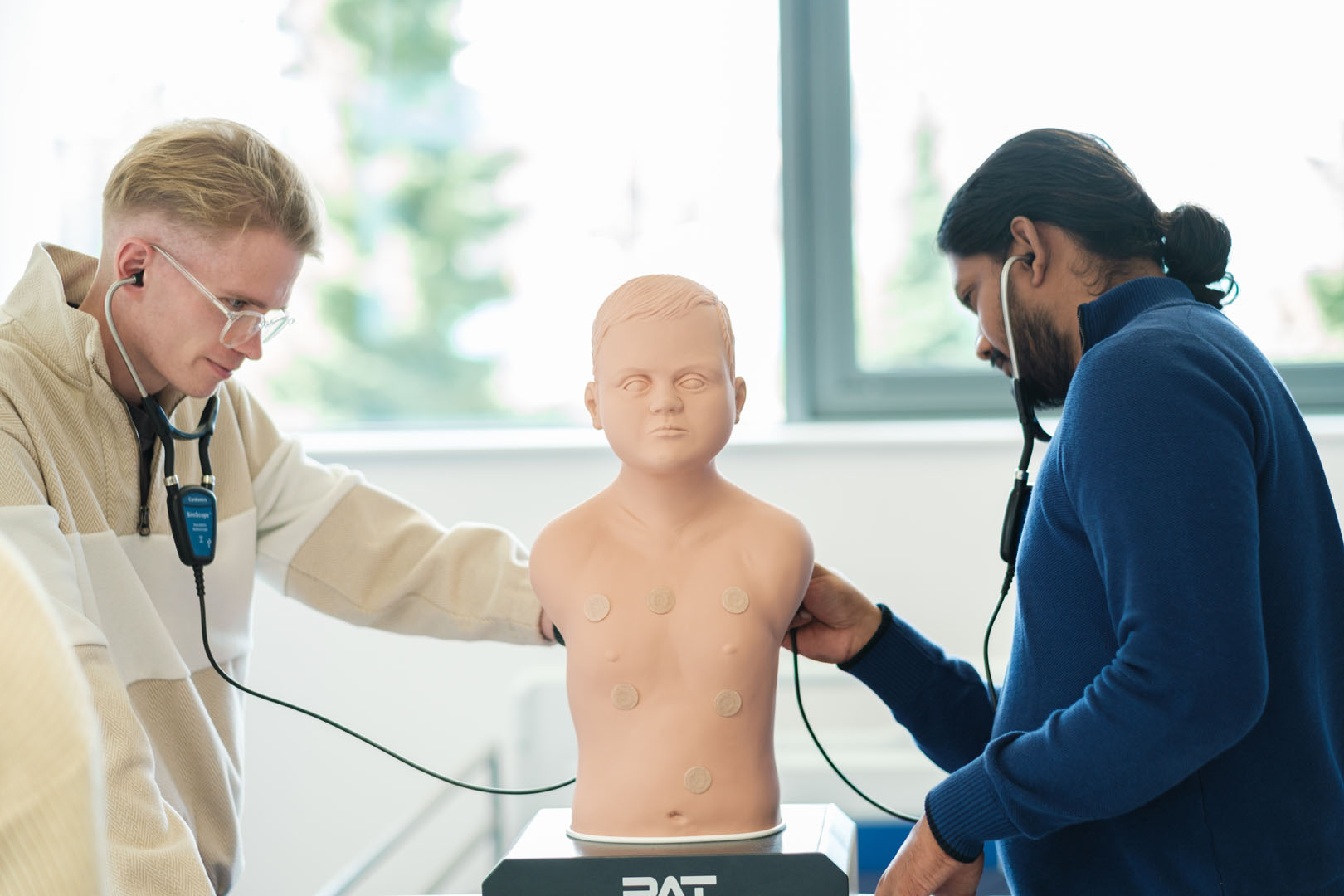 Students inspecting a medical dummy