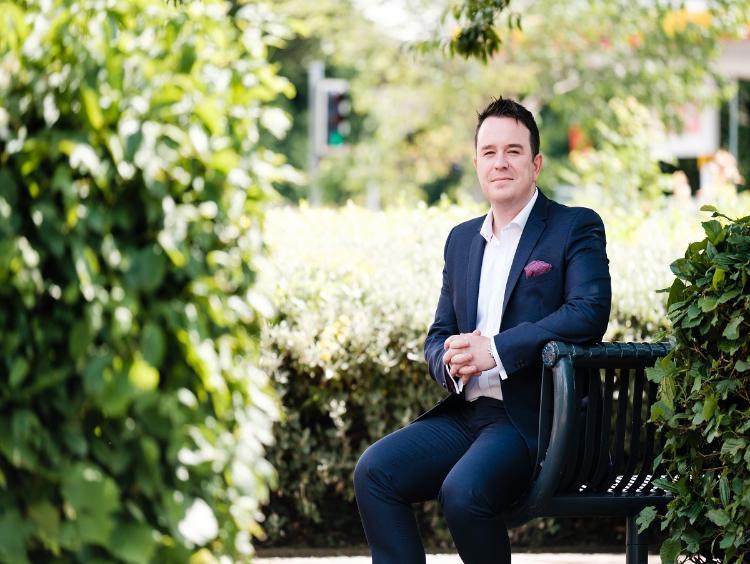 Student sitting outside wearing a suit