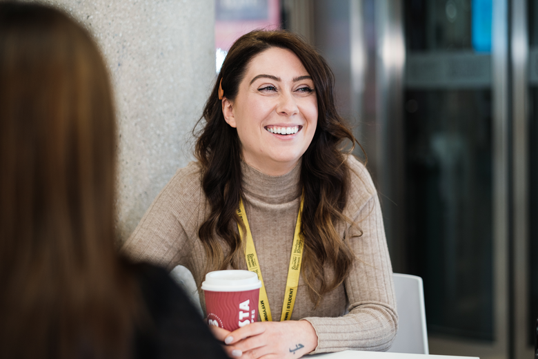 Student smiling coffee cup