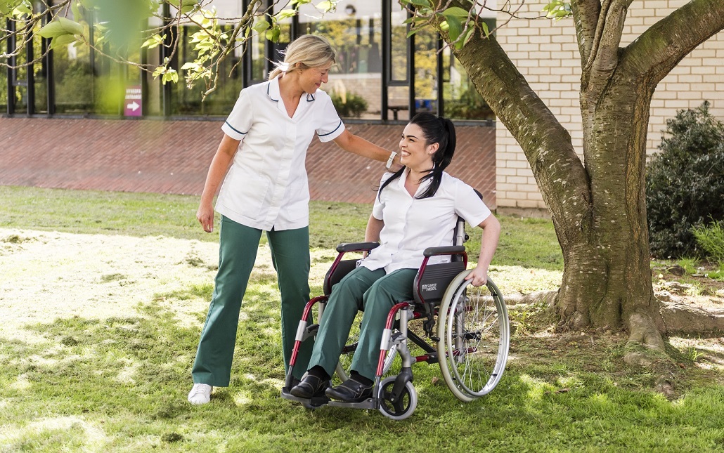 Occupational Therapy students outside with a wheelchair