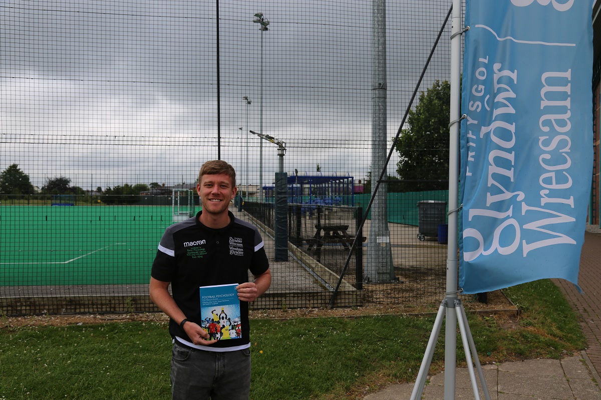 Tom King holding his Sports Psychology book