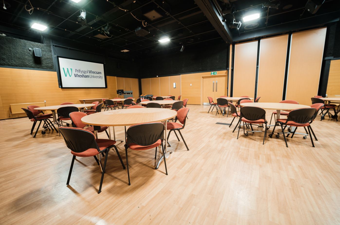Tables and chairs arranged in a large meeting room