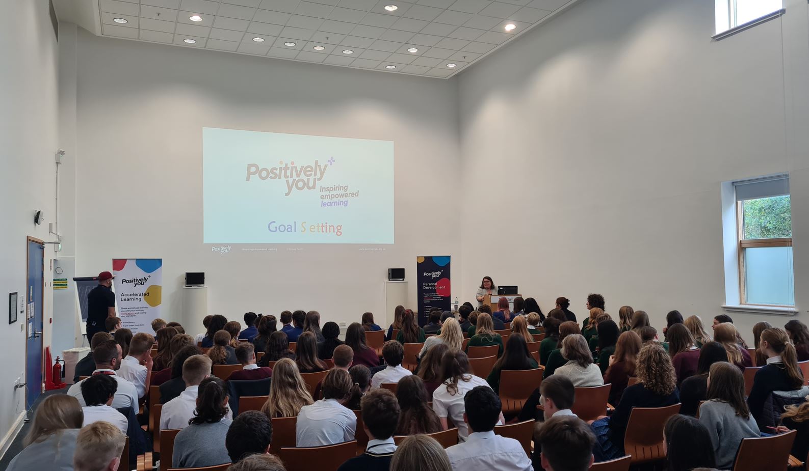 People in a large room watching a presentation