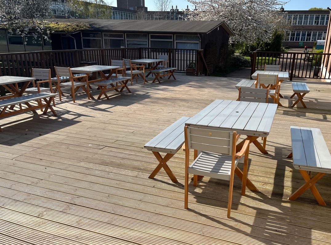 Tables and benches on an outdoor decking area