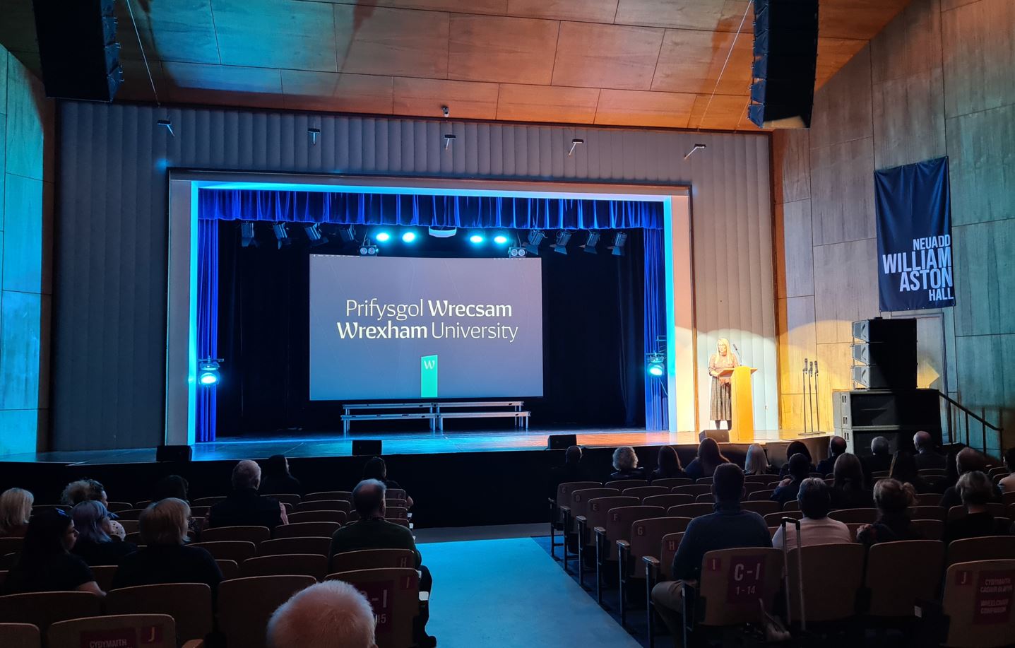 A speaker addressing an audience in a large theatre