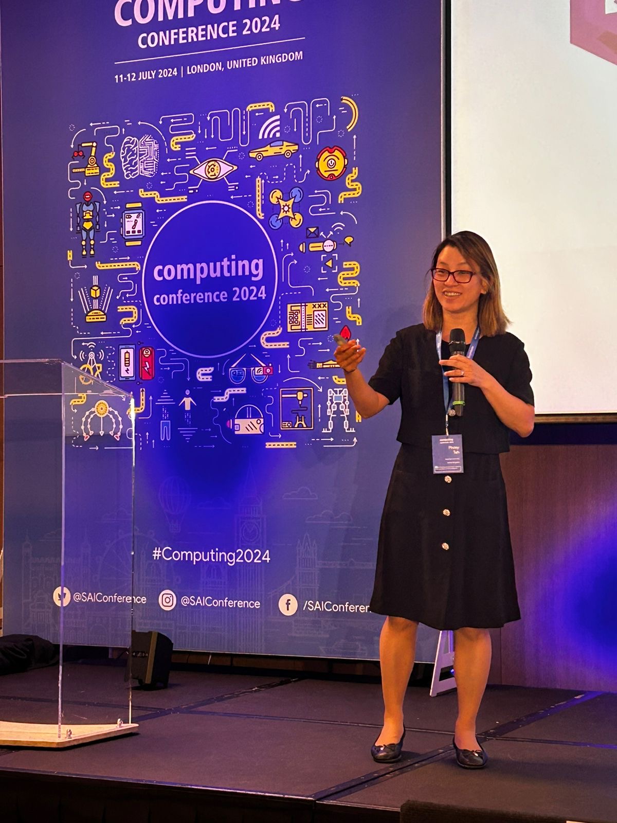 Staff member in front of a presentation screen at a conference