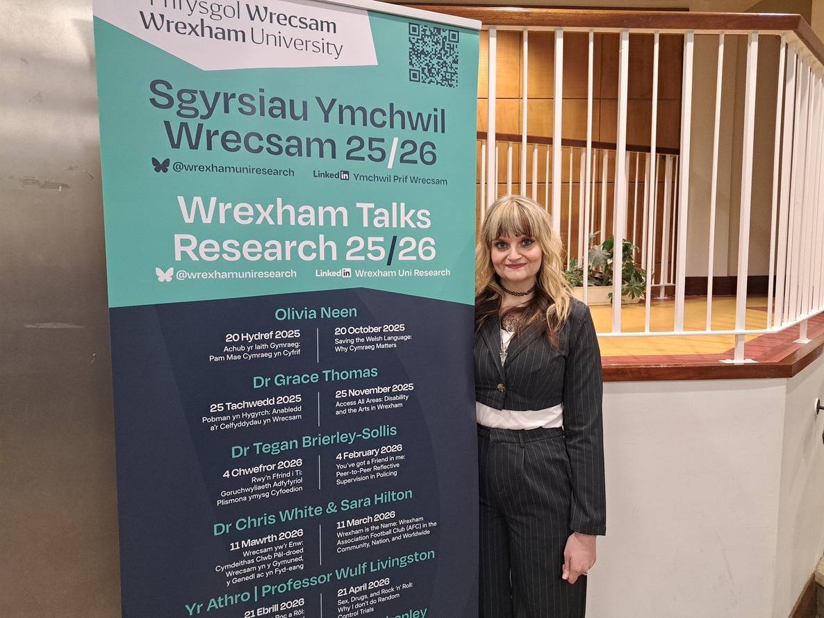 A staff member standing near an advertising banner