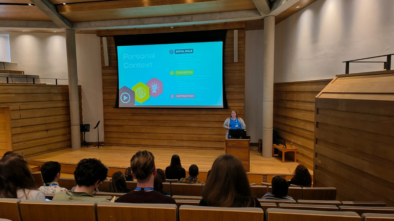 Conference speaker on stage behind a lectern with an audience