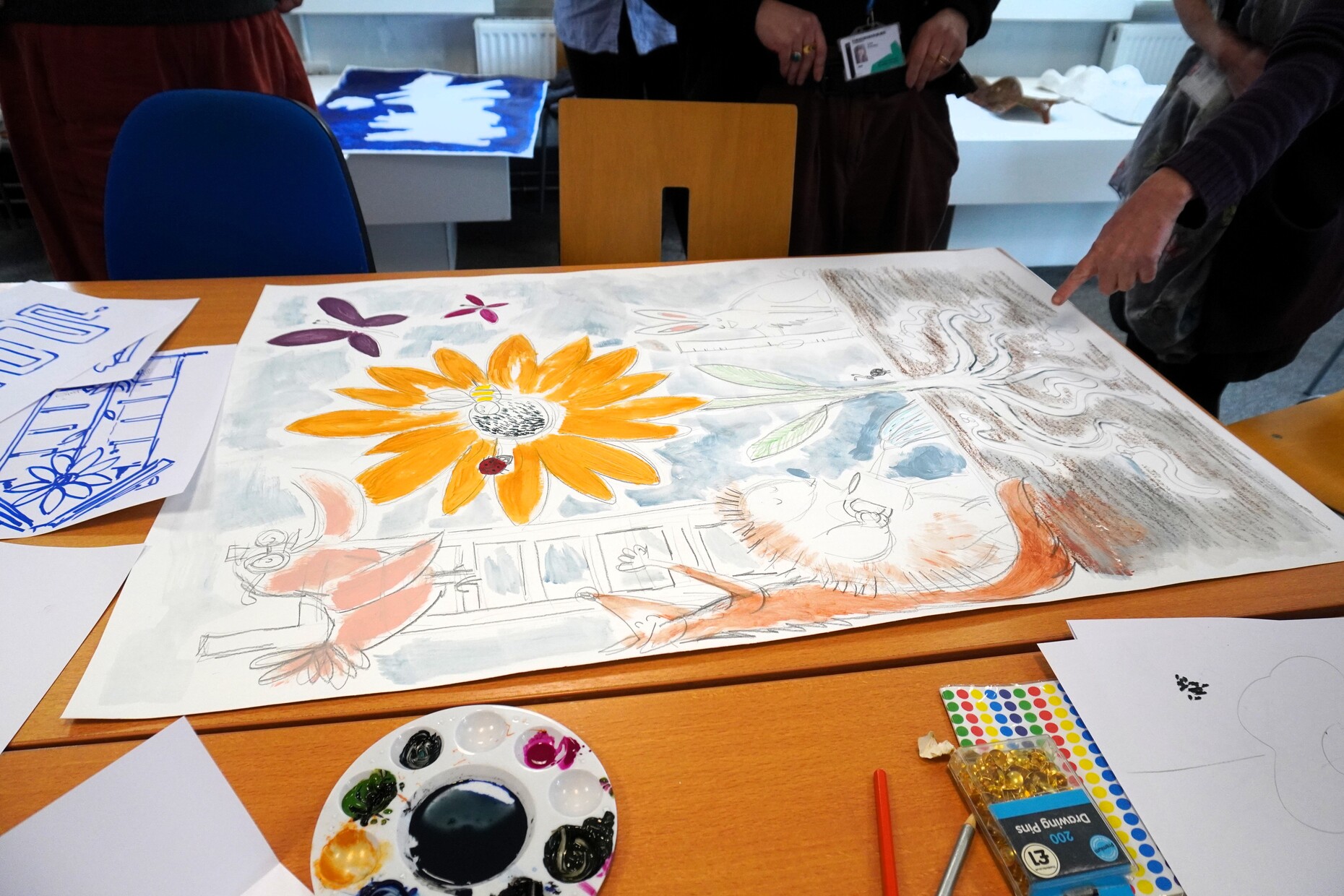 Art work on a large piece of paper on a table