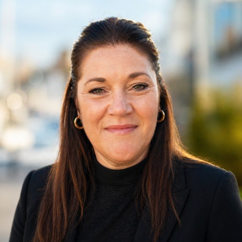 Head and shoulders shot of a researcher with long hair in a black top
