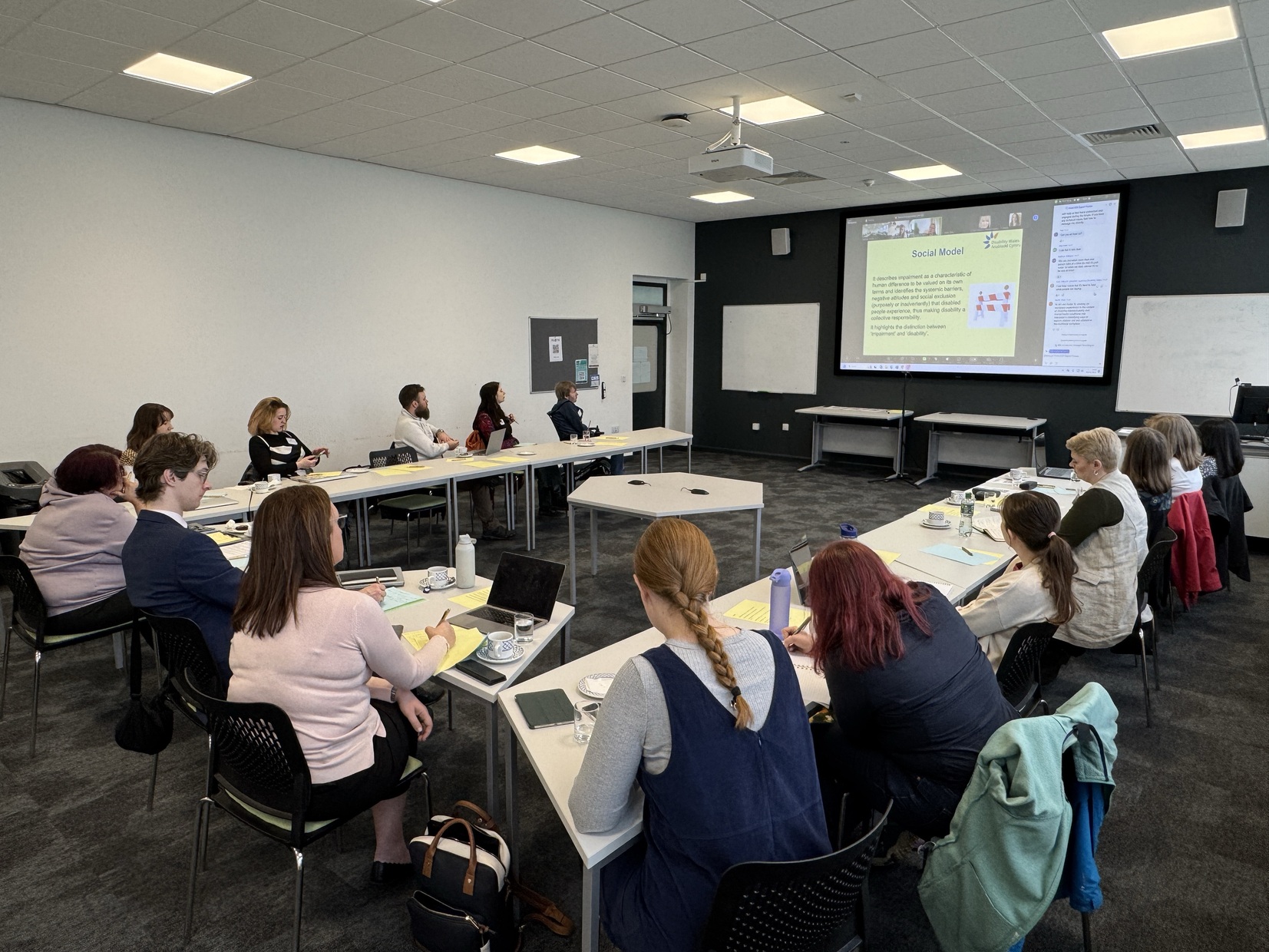 A group of attendees around a table during a presentation