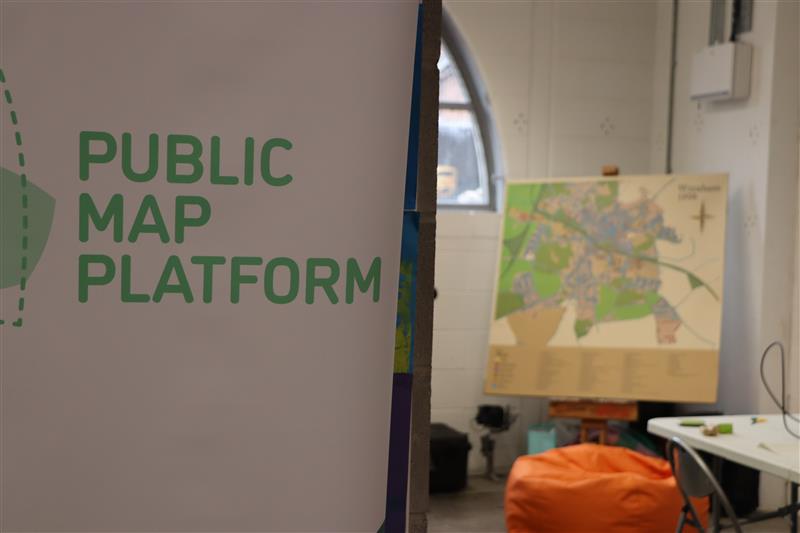 A sign that reads Public Map Platform with a map standing behind it