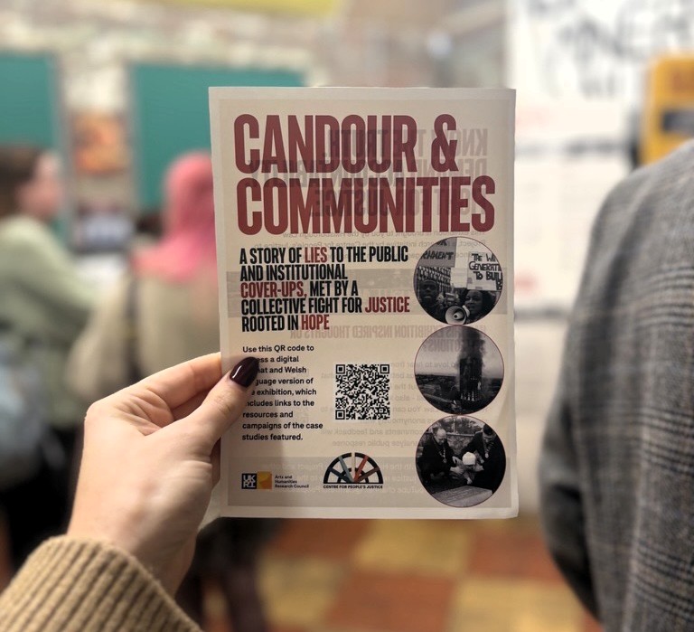 a hand holding a pamphlet for the event