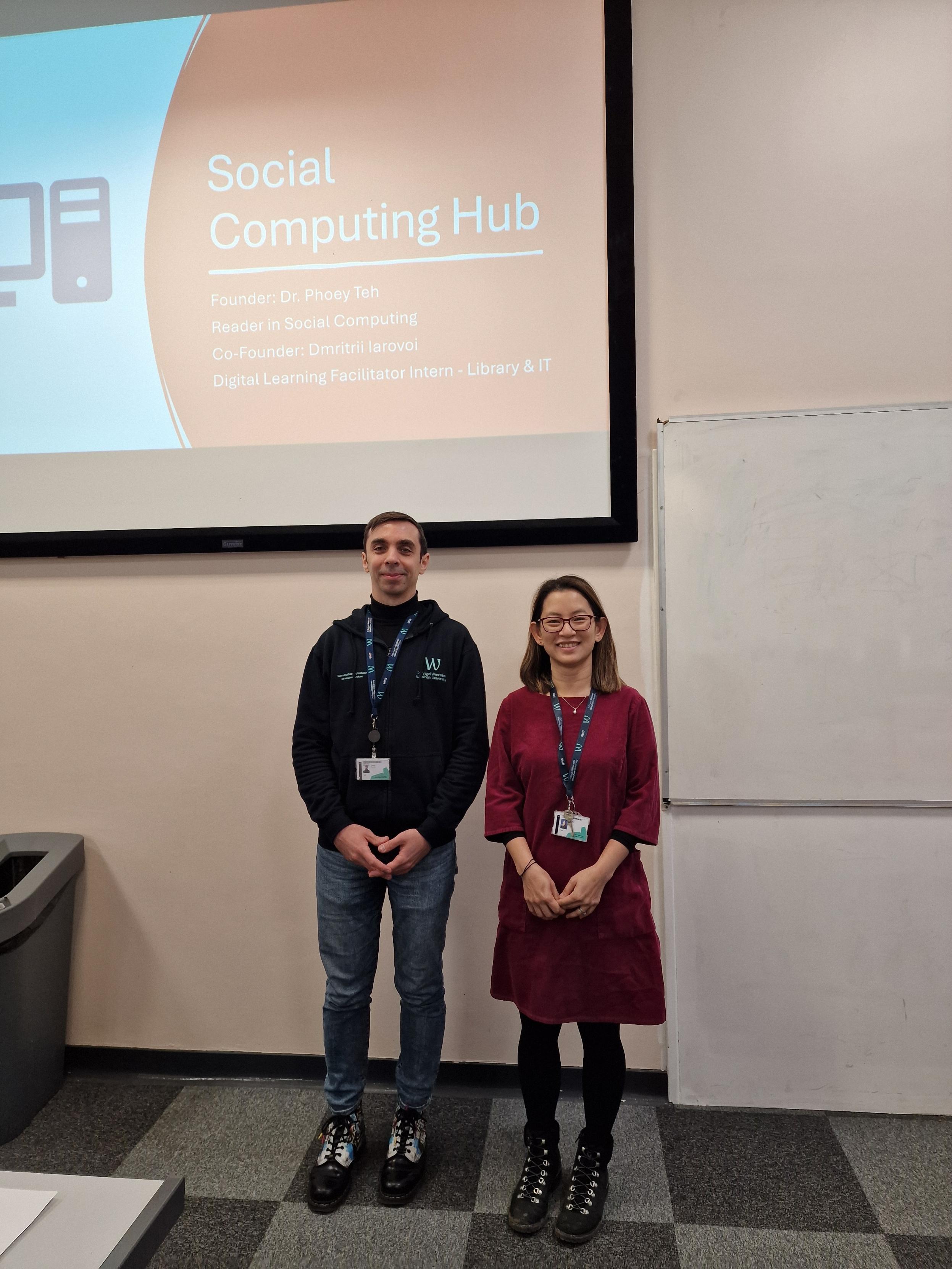 Two research colleagues in front of a presentation screen