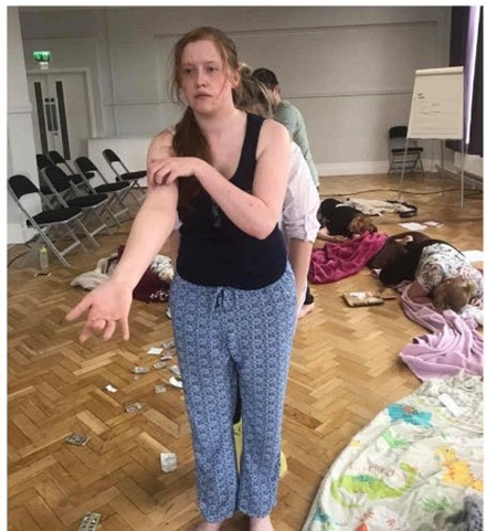 Performers dressed in comfortable clothing with blankets on floor