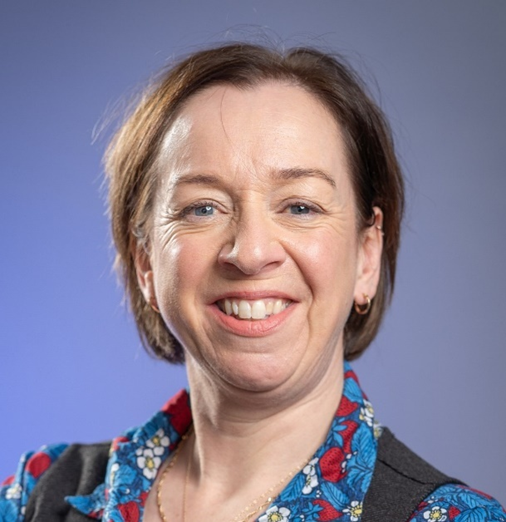 Head and shoulders shot of female against a blue background