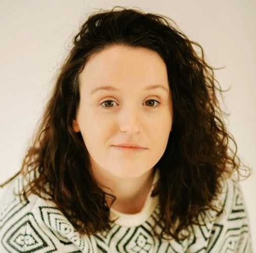 Head and shoulders shot of a female with long hair against a white background