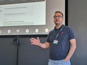 Speaker presenting in front of a large screen