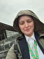 a person in a raincoat taking a selfie outside the senedd