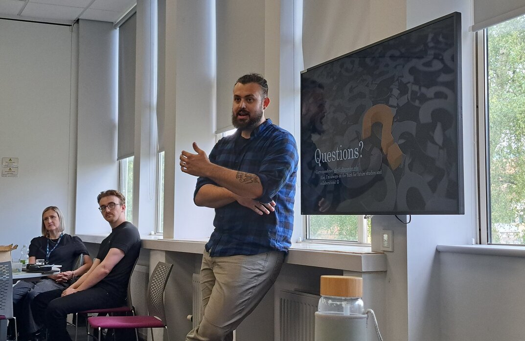 rob presenting in a blue check shirt