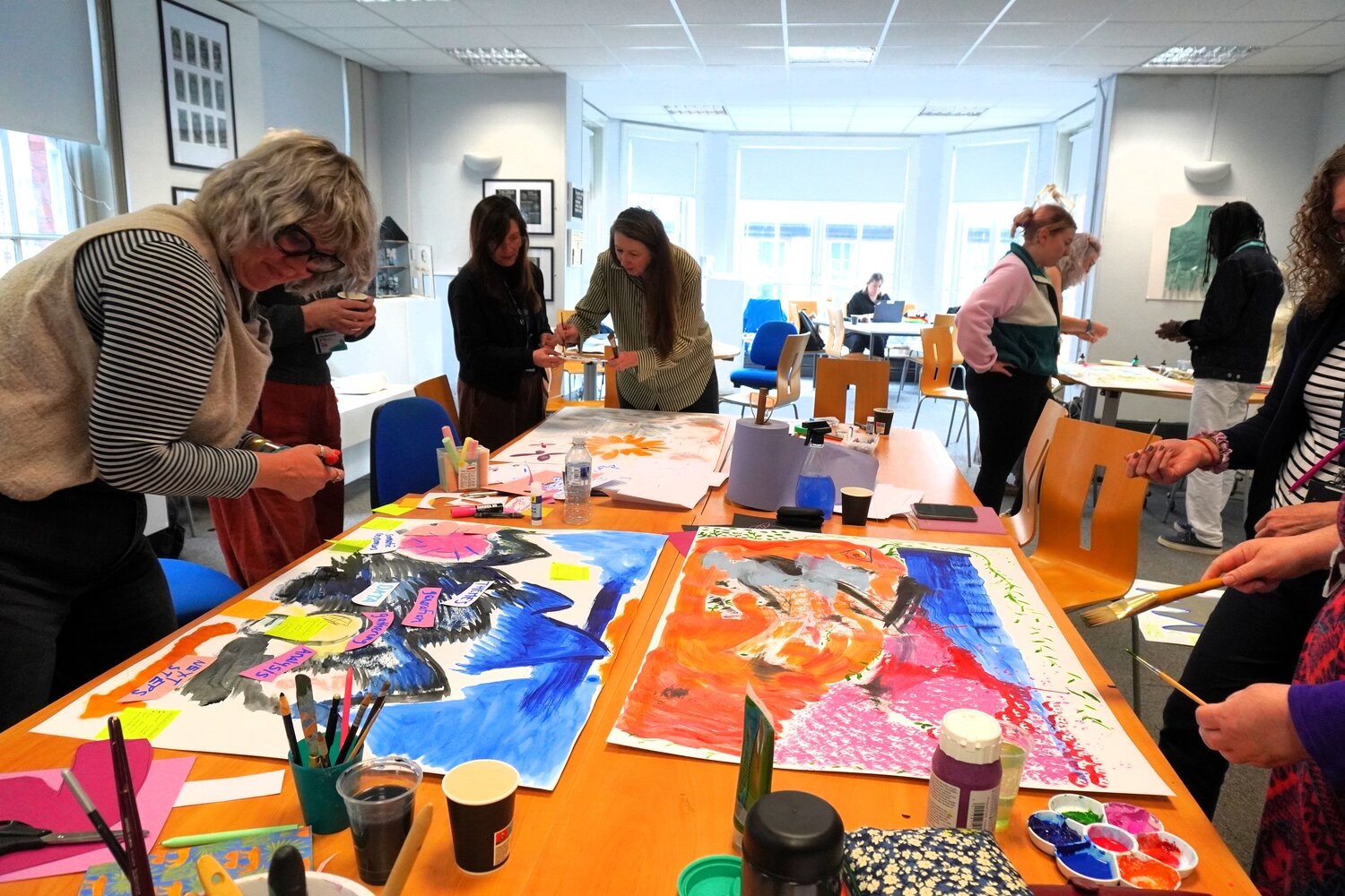 people painting and drawing around a big table