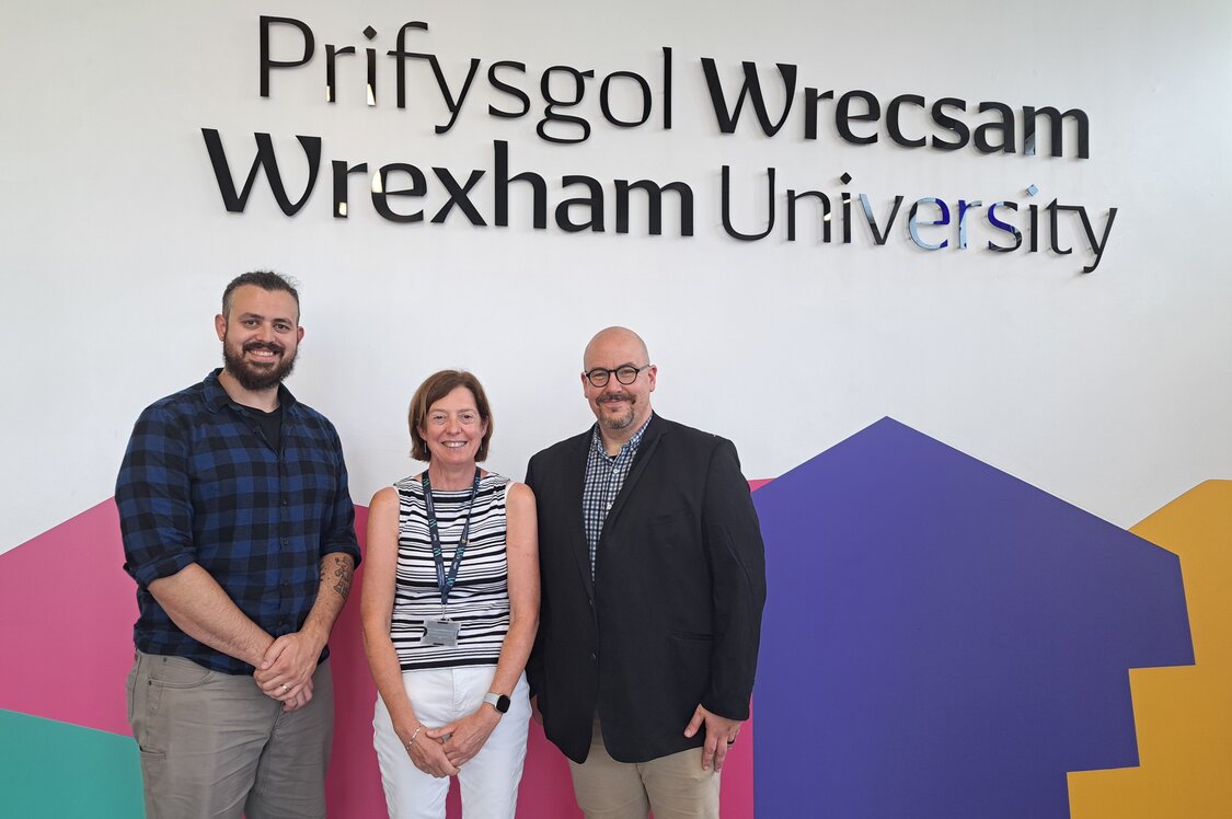 Rob Mandy Chris standing in front of wrexham uni sign