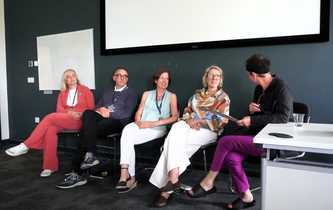 panel at the conference sitting in a row being asked questions